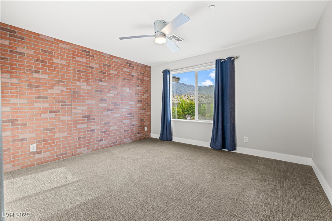 4631 Amazing View Street Las Vegas, NV 89129 - Photo 67 of 94 Spare room with brick wall, a mountain view, carpet, and ceiling fan