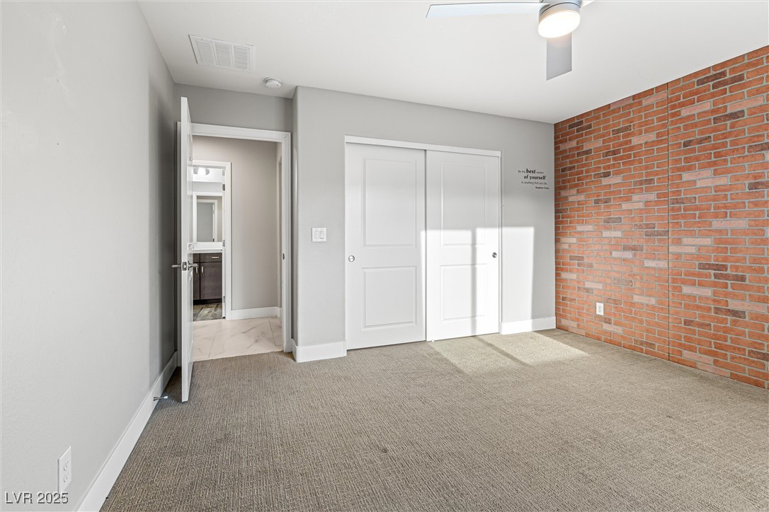 4631 Amazing View Street Las Vegas, NV 89129 - Photo 68 of 94 Unfurnished bedroom with brick wall, light carpet, a closet, and a ceiling fan