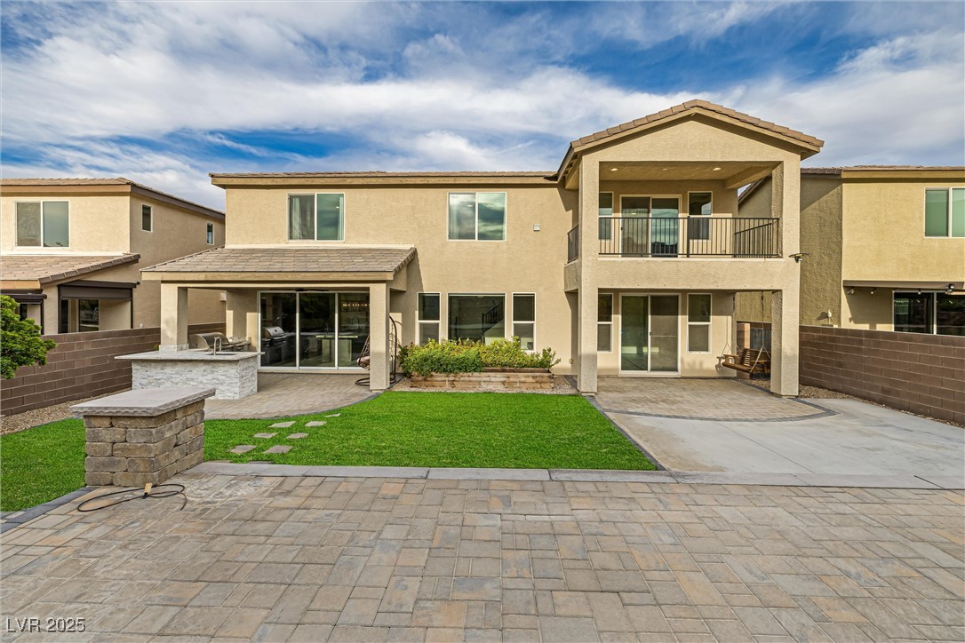 4631 Amazing View Street Las Vegas, NV 89129 - Photo 76 of 94 Rear view of property with an outdoor kitchen, stucco siding, a balcony, and a patio