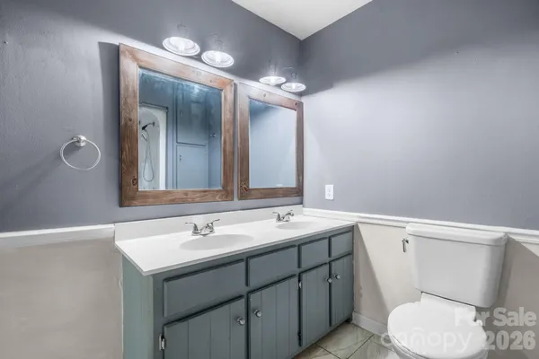 a bathroom with a sink a toilet a mirror and shower