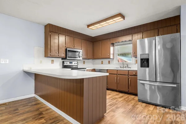 a kitchen with stainless steel appliances granite countertop a refrigerator stove top oven and sink
