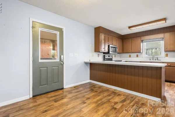 a kitchen with stainless steel appliances granite countertop a sink stove and cabinets
