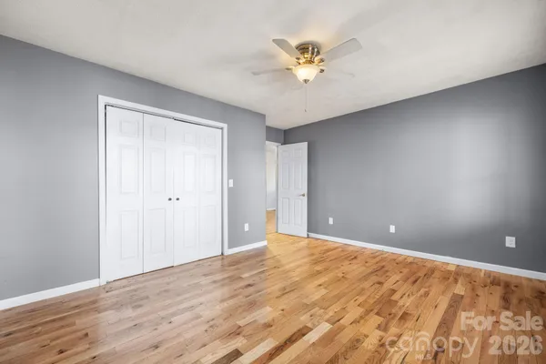 a view of an empty room and chandelier fan