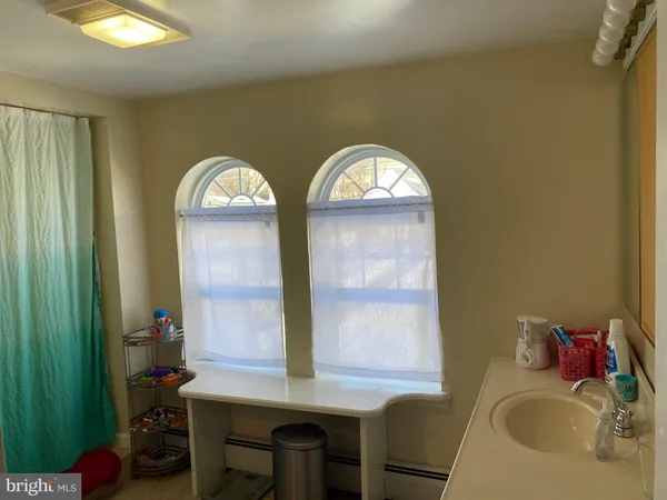 a bathroom with a sink a mirror and a window