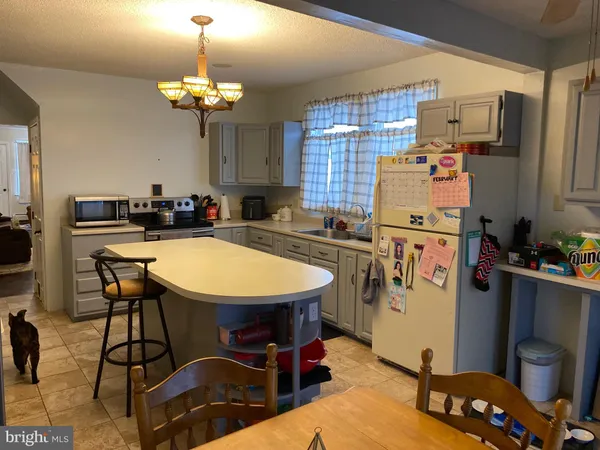 a room with a table chairs and a refrigerator