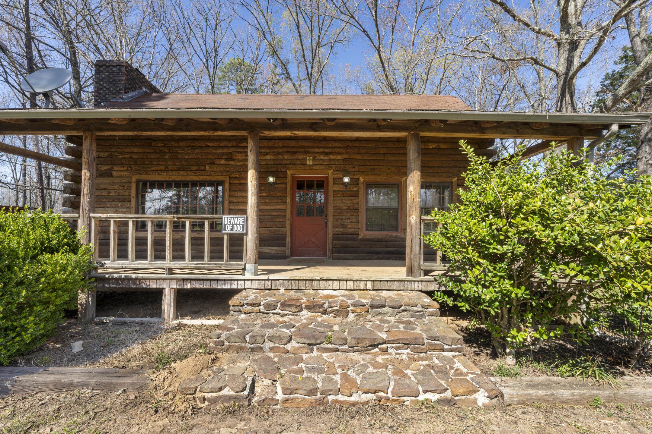7285 Peavine Road Middleton, TN 38052 - Photo 1 of 35 Property entrance featuring log siding, a chimney, and covered porch