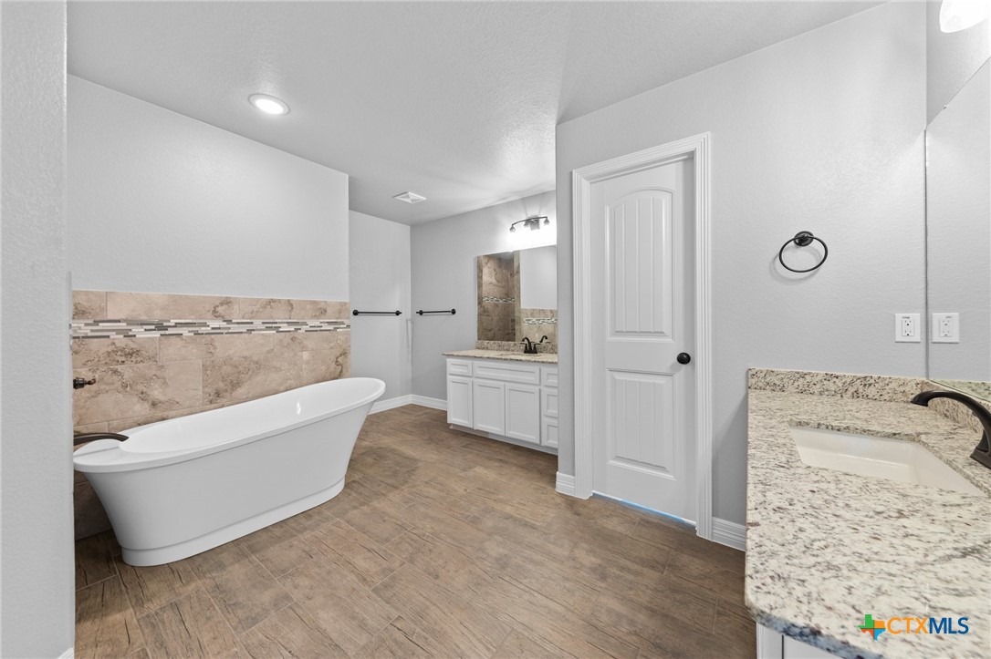 3030 Millhouse Road Copperas Cove, TX 76522 - Photo 15 of 24 a bathroom with a tub shower sink and mirror
