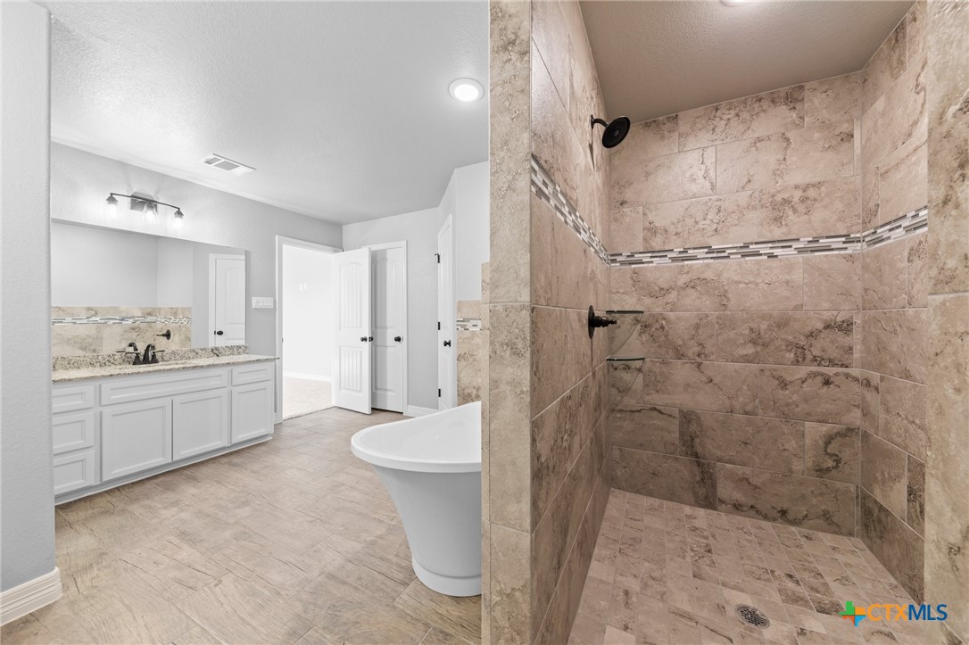 3030 Millhouse Road Copperas Cove, TX 76522 - Photo 21 of 24 a bathroom with a double vanity sink toilet mirror and shower