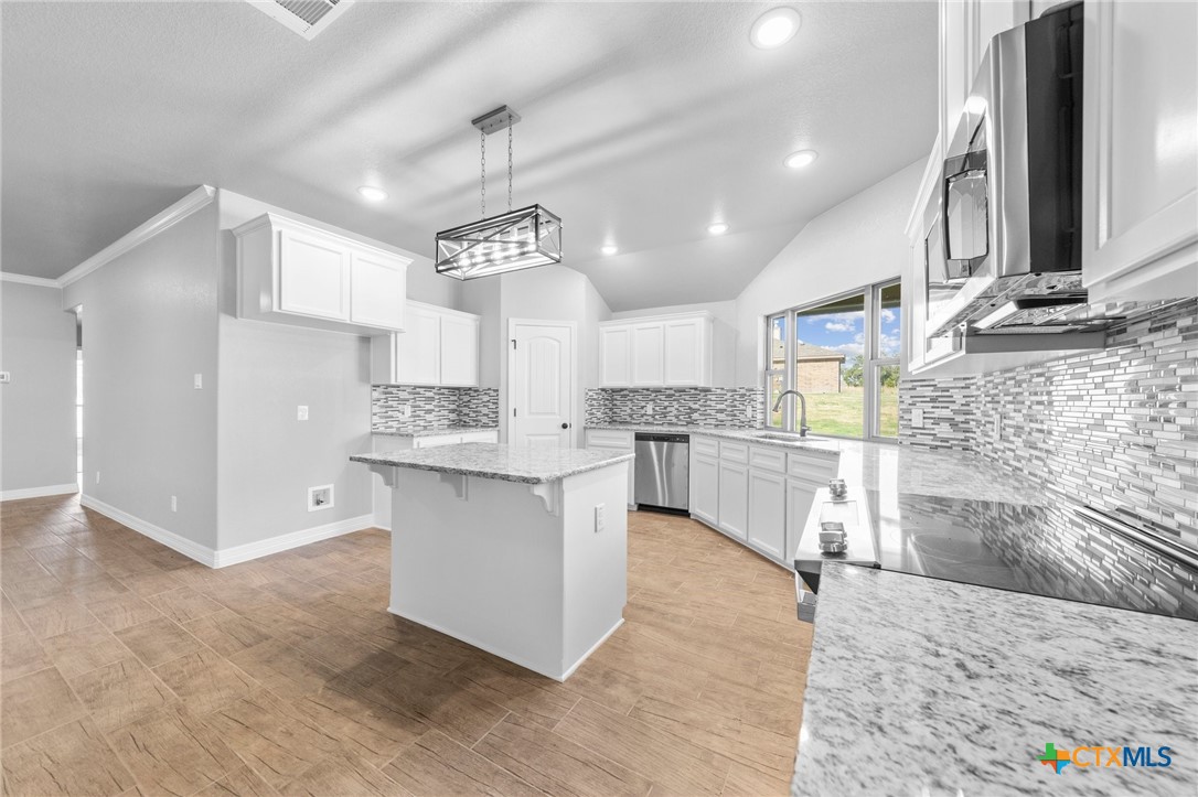 3030 Millhouse Road Copperas Cove, TX 76522 - Photo 23 of 24 a large kitchen with cabinets and stainless steel appliances