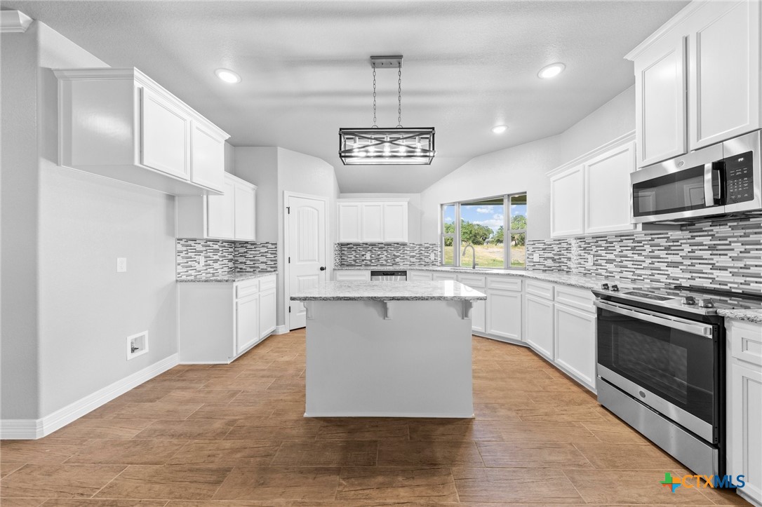 3030 Millhouse Road Copperas Cove, TX 76522 - Photo 3 of 24 a kitchen with a refrigerator cabinets and wooden floor