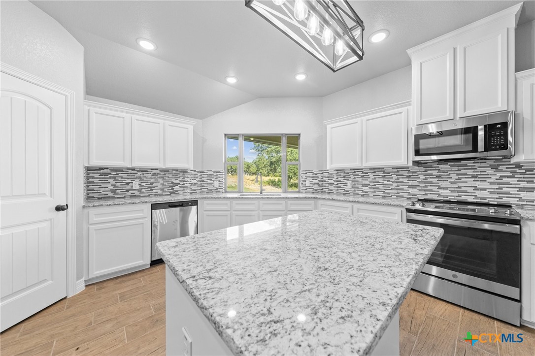 3030 Millhouse Road Copperas Cove, TX 76522 - Photo 5 of 24 a kitchen with stainless steel appliances granite countertop a sink stove and microwave