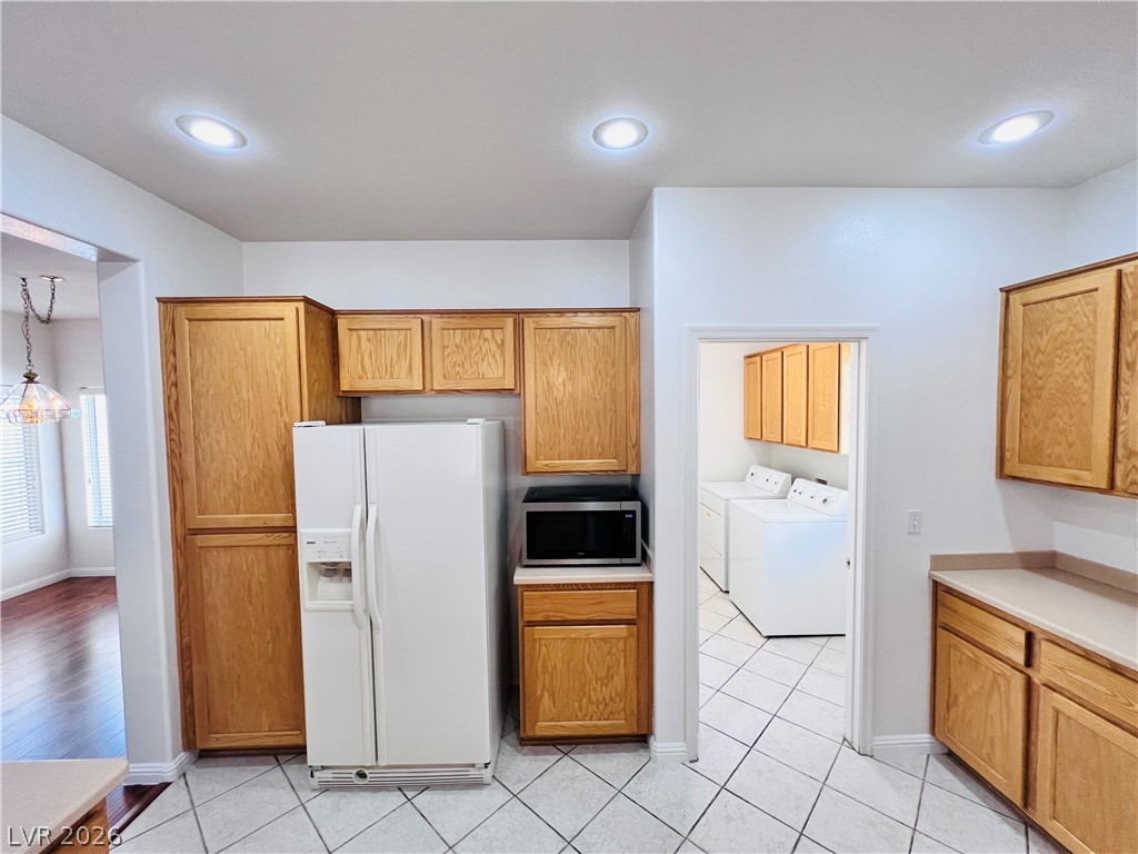3047 Hickory Valley Road Henderson, NV 89052 - Photo 8 of 33 A well-appointed kitchen offers recessed lighting and ample wood cabinetry, with a convenient adjacent laundry room.