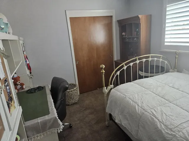 a bedroom with a bed chair and a window