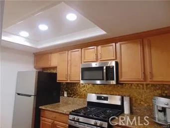 a kitchen with stainless steel appliances granite countertop a refrigerator stove and microwave