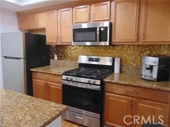 a kitchen with stainless steel appliances granite countertop a stove microwave refrigerator and sink
