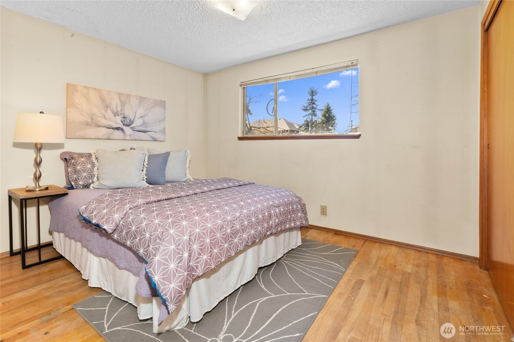 513 Harrington Avenue Northeast Renton, WA 98056 - Photo 17 of 33 a bedroom with a large bed and a painting on the wall