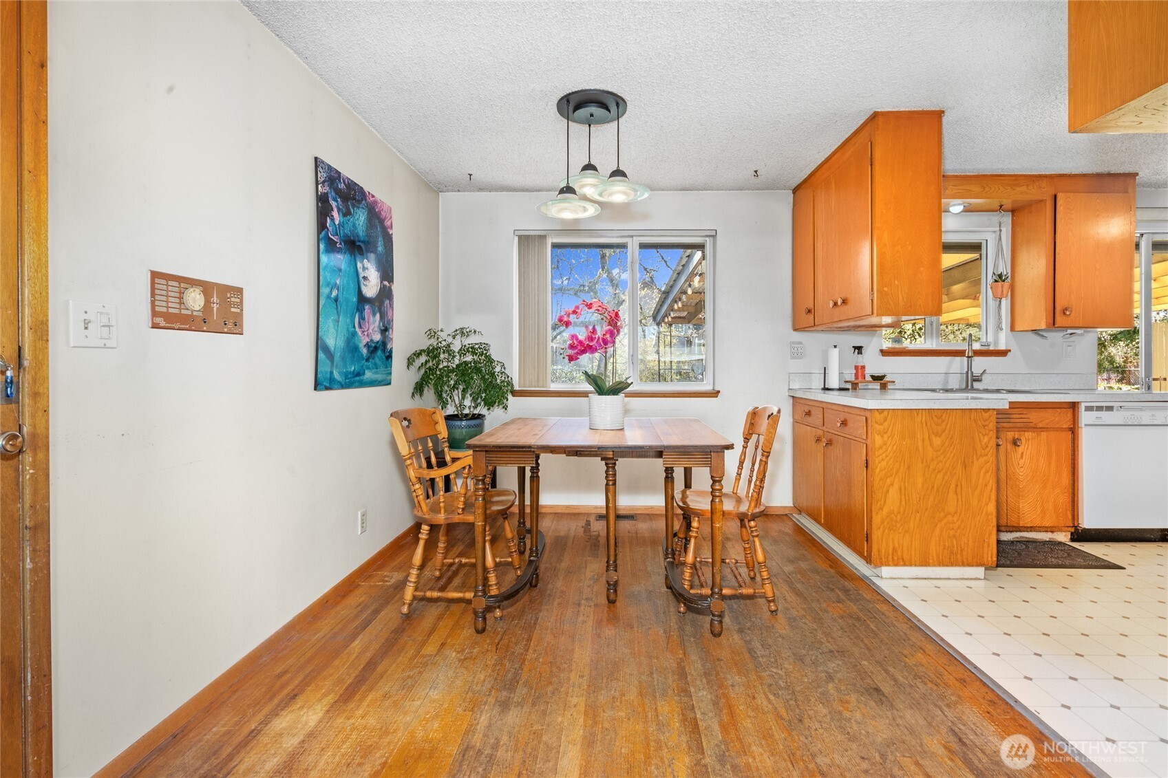 513 Harrington Avenue Northeast Renton, WA 98056 - Photo 7 of 33 a dining room with wooden floor a chandelier a wooden table and chairs
