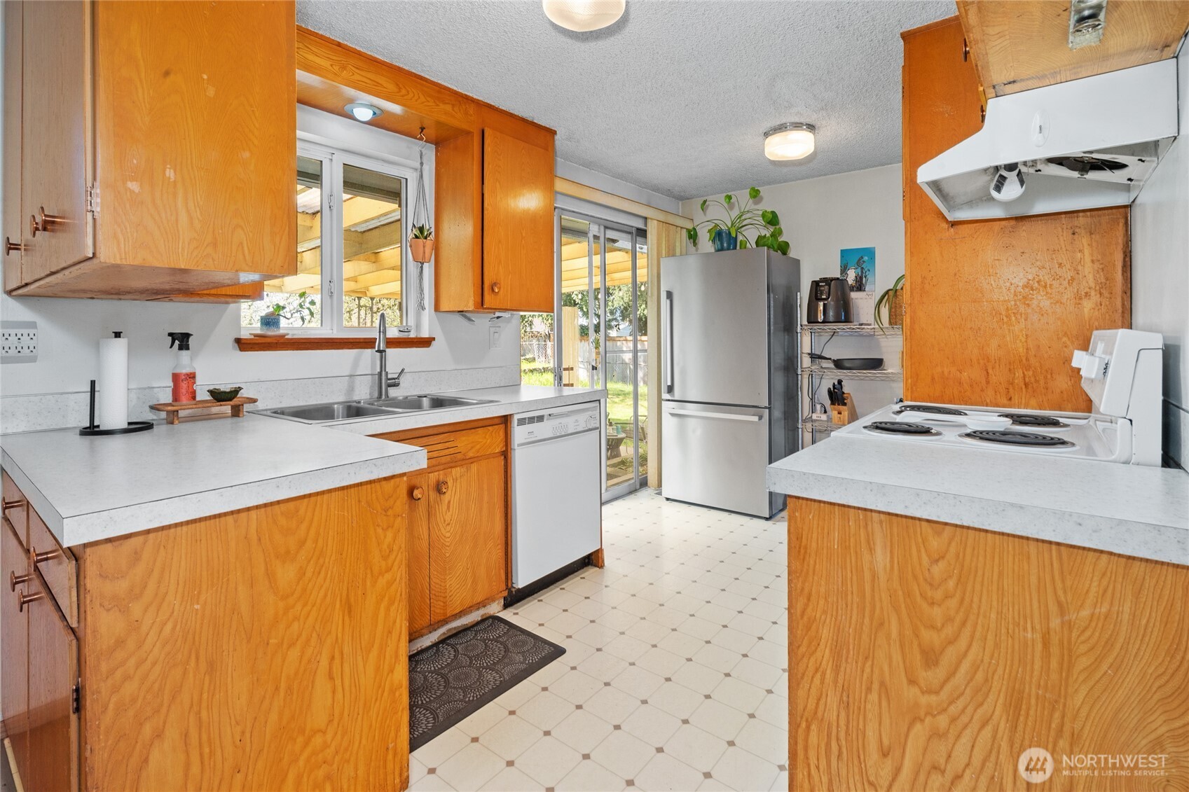 513 Harrington Avenue Northeast Renton, WA 98056 - Photo 8 of 33 a kitchen with a sink a refrigerator and a stove top oven