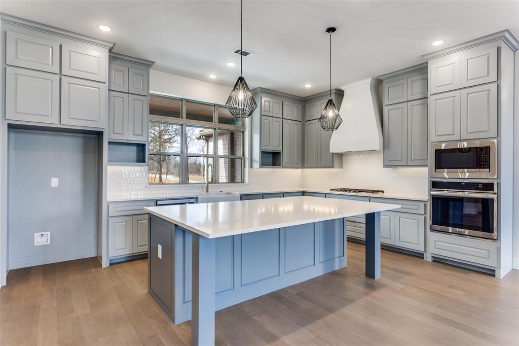 a kitchen with kitchen island granite countertop a sink stainless steel appliances and cabinets