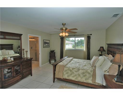 112 Northwest S Shore Road Stuart, FL 34994 - Photo 8 of 16 a bedroom with a bed and wooden floor