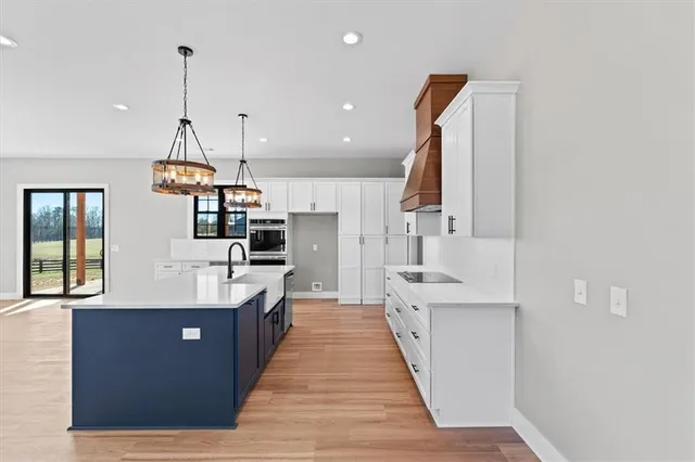 a large kitchen with stainless steel appliances kitchen island granite countertop a sink and cabinets