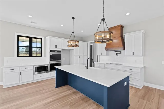 a kitchen with a sink stove and wooden floor