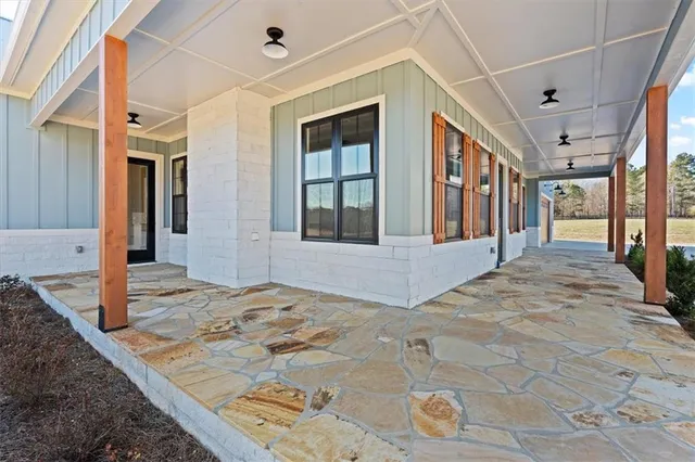 a view of a hallway with wooden floor and a living room