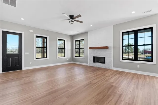 a view of an empty room with a window and fireplace
