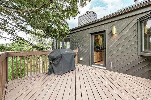 a balcony with wooden floor table and chairs