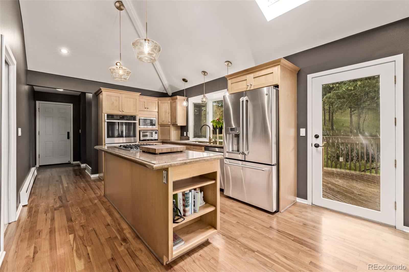 1139 Genesee Vista Road Golden, CO 80401 - Photo 14 of 43 a kitchen with stainless steel appliances granite countertop a refrigerator a sink dishwasher a stove and a dining table with wooden floor