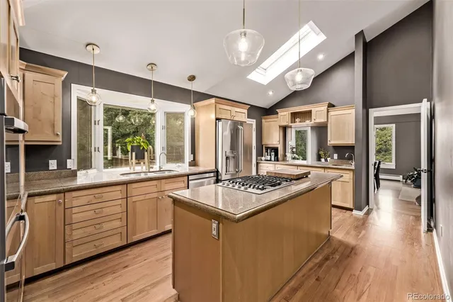 a kitchen with stainless steel appliances granite countertop a stove refrigerator and cabinets