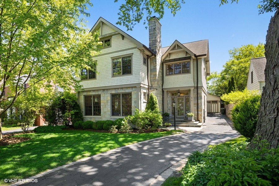 576 Sunset Road Winnetka, IL 60093 - Photo 1 of 42 a front view of a house with a garden and plants
