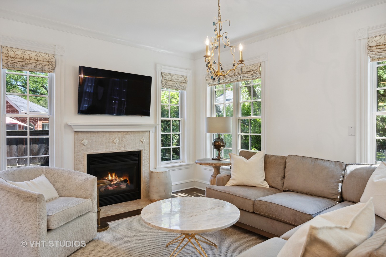 576 Sunset Road Winnetka, IL 60093 - Photo 13 of 42 a living room with furniture a chandelier and a fireplace