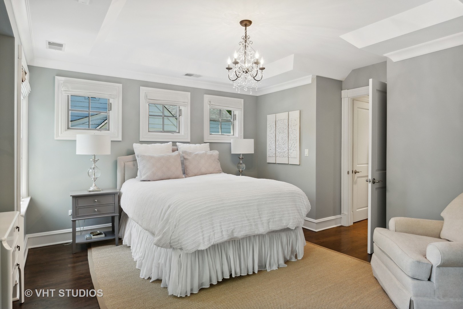 576 Sunset Road Winnetka, IL 60093 - Photo 18 of 42 a spacious bedroom with a bed and a chandelier