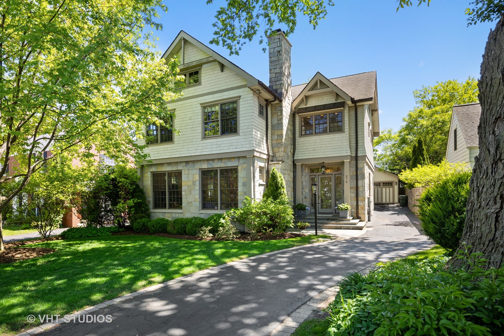576 Sunset Road Winnetka, IL 60093 - Photo 2 of 42 a front view of a house with a garden and trees