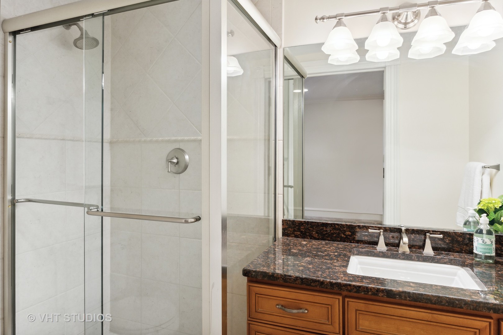 576 Sunset Road Winnetka, IL 60093 - Photo 31 of 42 a bathroom with a granite countertop sink mirror and a shower