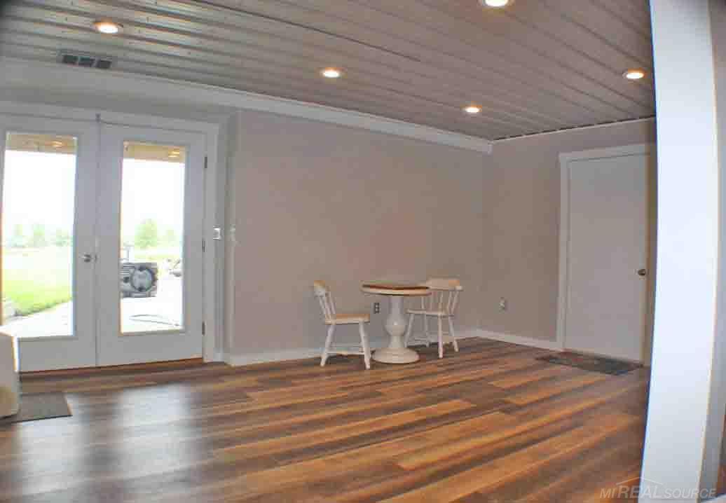 8577 Peck Road Marlette, MI 48453 - Photo 24 of 27 Another part of the finished basement (25.3x23.8) The door to the back right of the photo leads out to the 2 car garage.