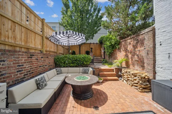 a view of a patio with couches table and chairs and potted plants