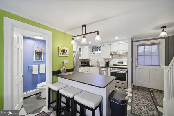 a kitchen with a dining table chairs and refrigerator