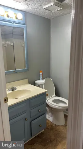 a view of a refrigerator in kitchen and an empty room