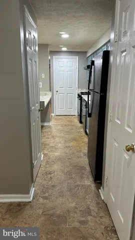 a view of kitchen with stainless steel appliances wooden floor and view living room