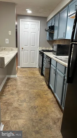 a kitchen with stainless steel appliances a stove a sink and a microwave