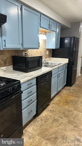 a kitchen with granite countertop a stove and cabinets