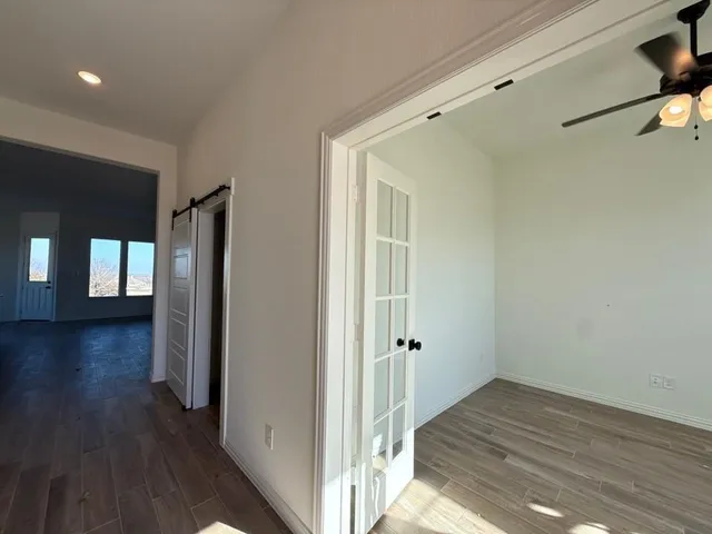 a view of a hallway with wooden floor and closet area
