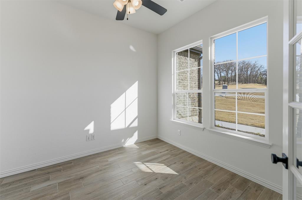 404 Hayden Faith Court Springtown, TX 76082 - Photo 6 of 24 an empty room with wooden floor chandelier fan and windows