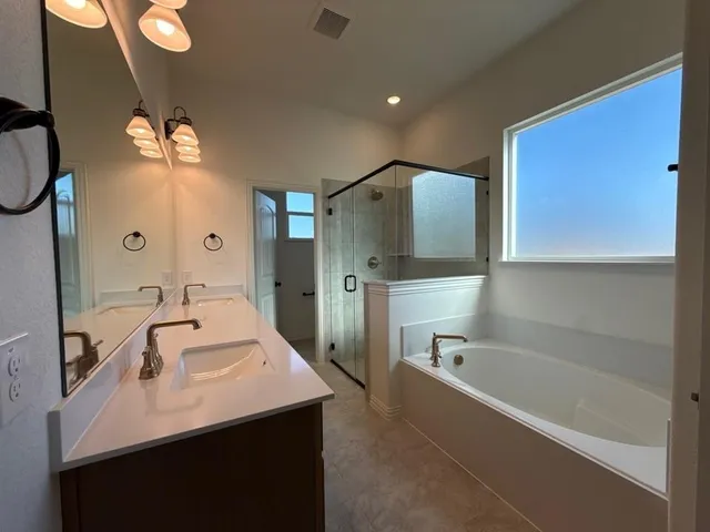 a bathroom with a tub sink and mirror
