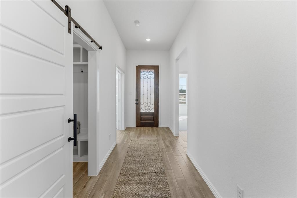 404 Hayden Faith Court Springtown, TX 76082 - Photo 10 of 24 a view of a hallway with wooden floor and staircase