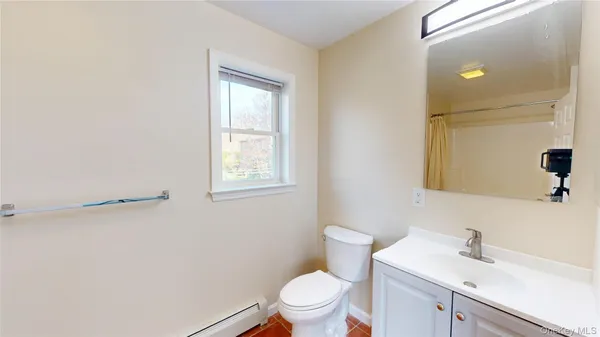a bathroom with a toilet a sink a mirror and vanity