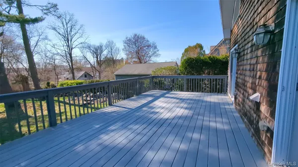 a balcony with wooden floor and yard in the back
