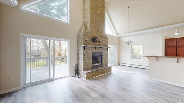 an empty room with windows a fireplace and wooden floor